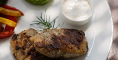 Prato de frango grelhado bem servido com acompanhamentos