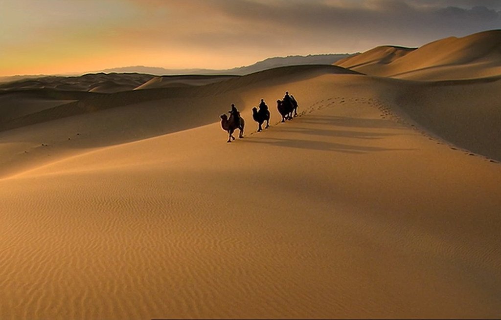 Caravana de camelos atravessando o deserto na antiga Rota da Seda