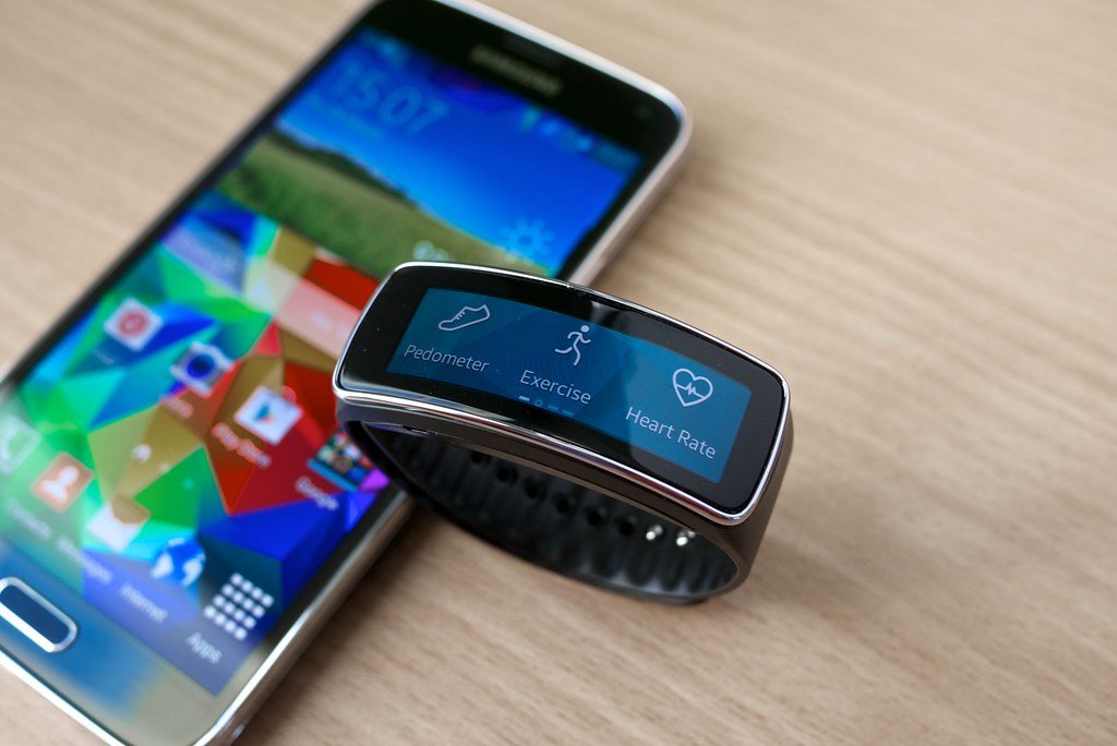 Smartwatch no pulso mostrando tela com dados de saúde e fitness